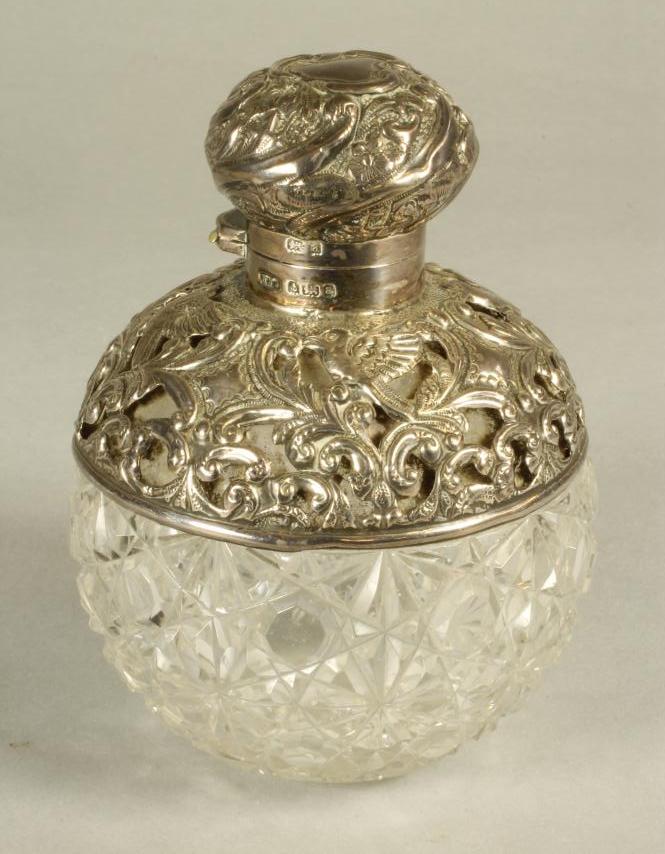 A LATE VICTORIAN GLASS SCENT BOTTLE AND STOPPER of globular form with hob-nail cutting and star cut Image