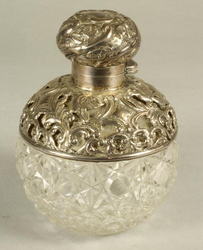 A LATE VICTORIAN GLASS SCENT BOTTLE AND STOPPER of globular form with hob-nail cutting and star cut Image
