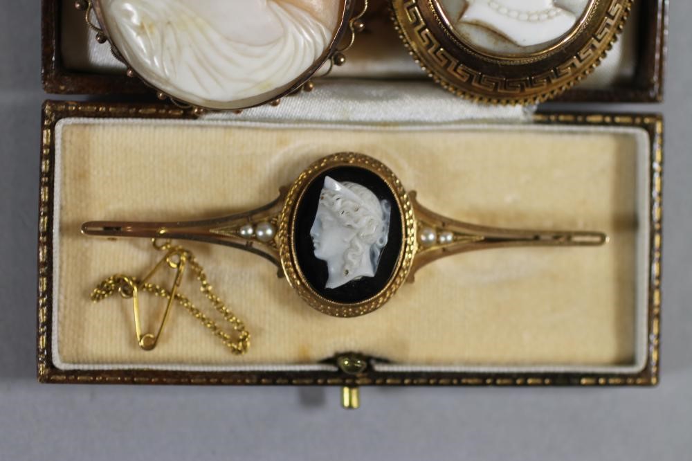 A VICTORIAN 15CT GOLD PROPELLOR BROOCH centred by an oval sardonyx plaque carved in high relief with Image