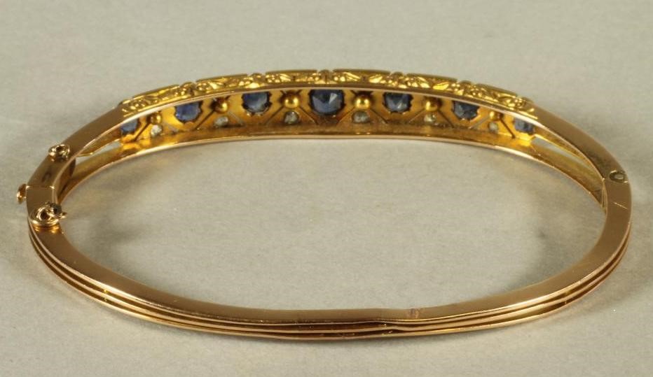 A VICTORIAN SAPPHIRE AND DIAMOND SET STIFF HINGED BANGLE Image