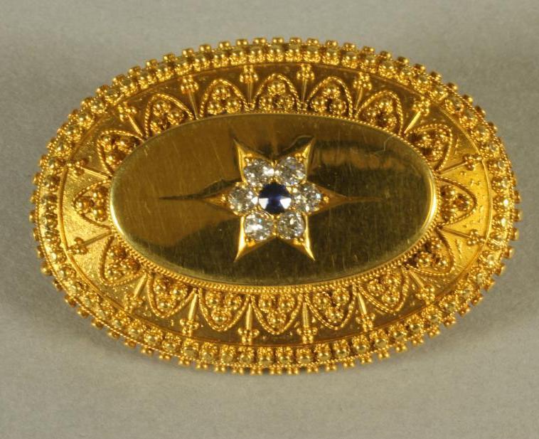 A VICTORIAN 15CT GOLD BROOCH of swept oval form with applied filigree work border Image