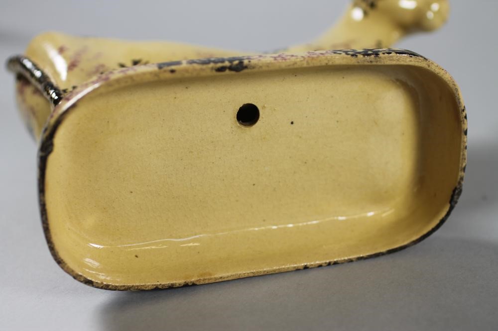 AN ENGLISH BUFF GLAZED EARTHENWARE MODEL OF A COW AND CALF Image