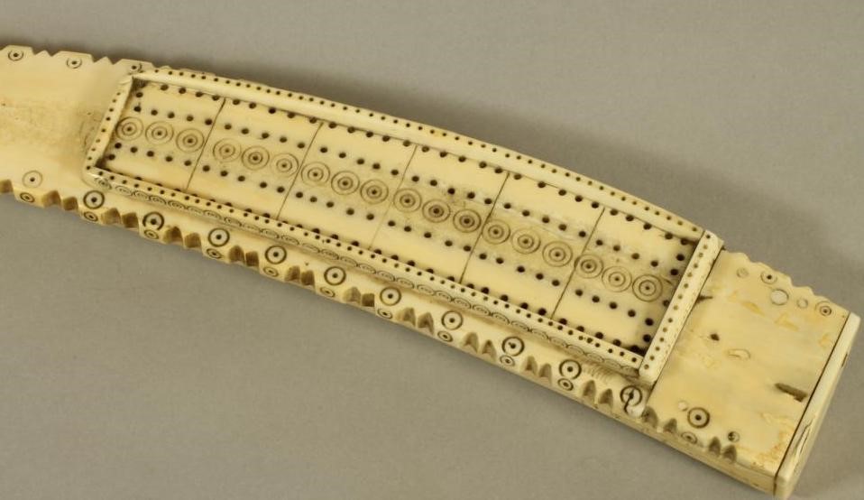 A WALRUS TUSK SCRIMSHAW CRIBBAGE BOARD Image