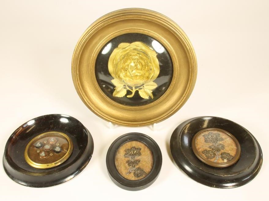 A VICTORIAN ORMOLU SMALL PLAQUE cast as a cupid kneeling within a full blown rose Image