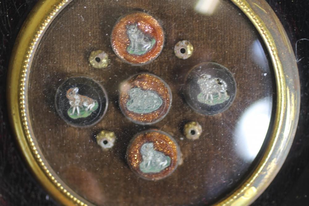 A VICTORIAN ORMOLU SMALL PLAQUE cast as a cupid kneeling within a full blown rose Image