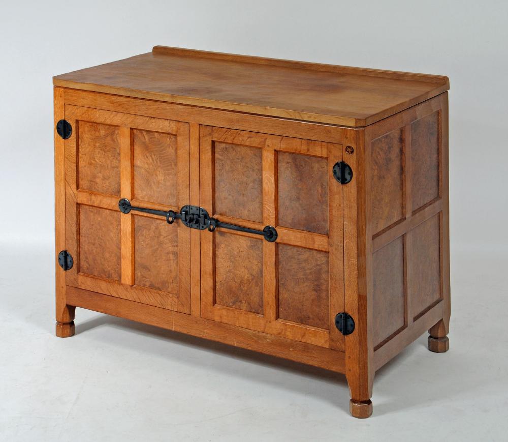 A MALCOLM PIPES ADZED OAK AND BURR OAK SIDE CABINET of canted multi panelled form Image