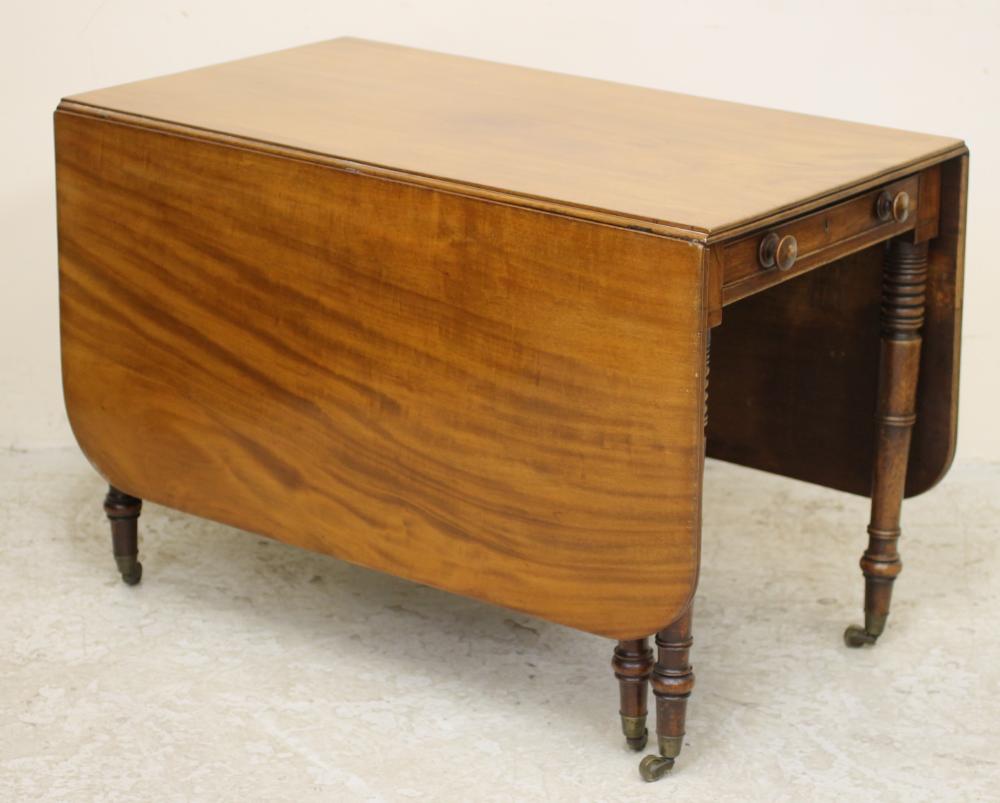 A REGENCY MAHOGANY DROP LEAF DINING TABLE of rounded oblong form with reeded edged top Image