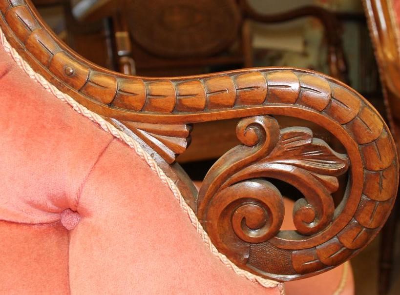 A VICTORIAN WALNUT FRAMED CHAPERONE SOFA button upholstered in pink dralon and surmounted by a Image