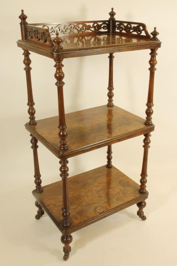A VICTORIAN WALNUT THREE TIER WHATNOT of rounded oblong form Image