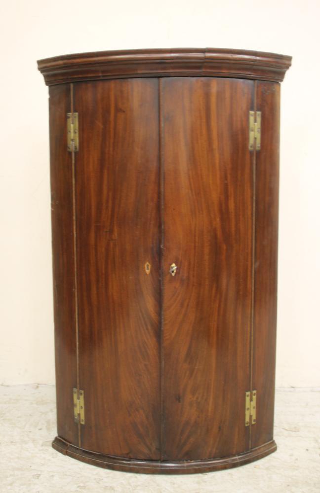 A GEORGIAN MAHOGANY CORNER CUPBOARD of quadrant form Image