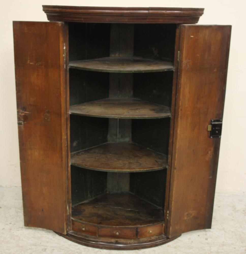 A GEORGIAN MAHOGANY CORNER CUPBOARD of quadrant form Image