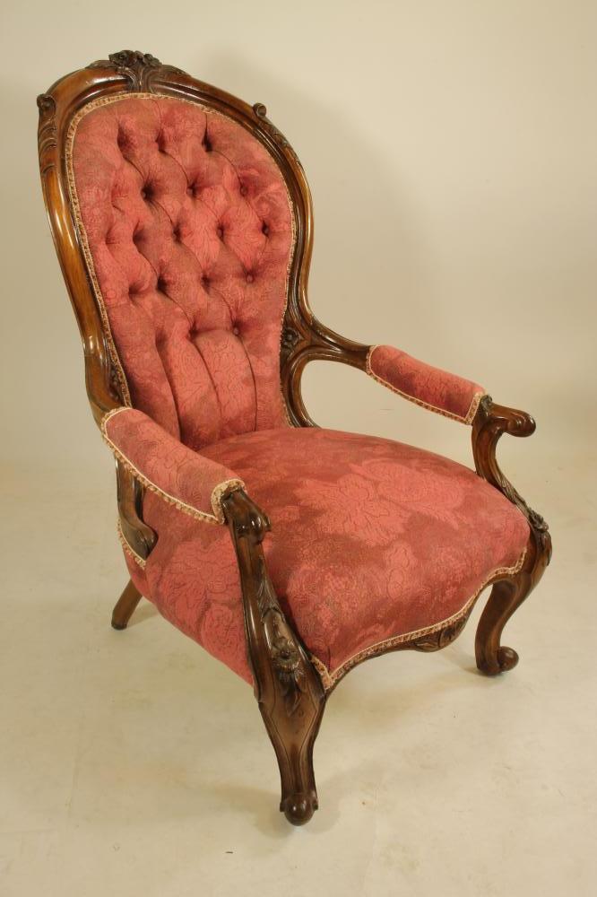 A VICTORIAN WALNUT FRAMED ARM CHAIR of spoonback form button upholstered in raspberry weave Image