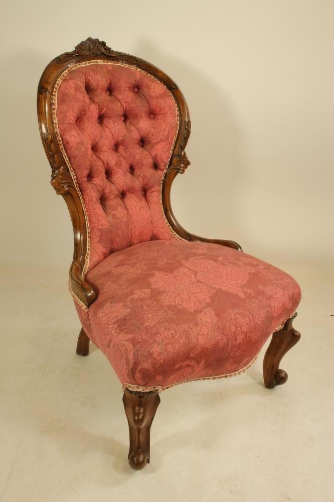 A VICTORIAN WALNUT FRAMED ARM CHAIR of spoonback form button upholstered in raspberry weave Image