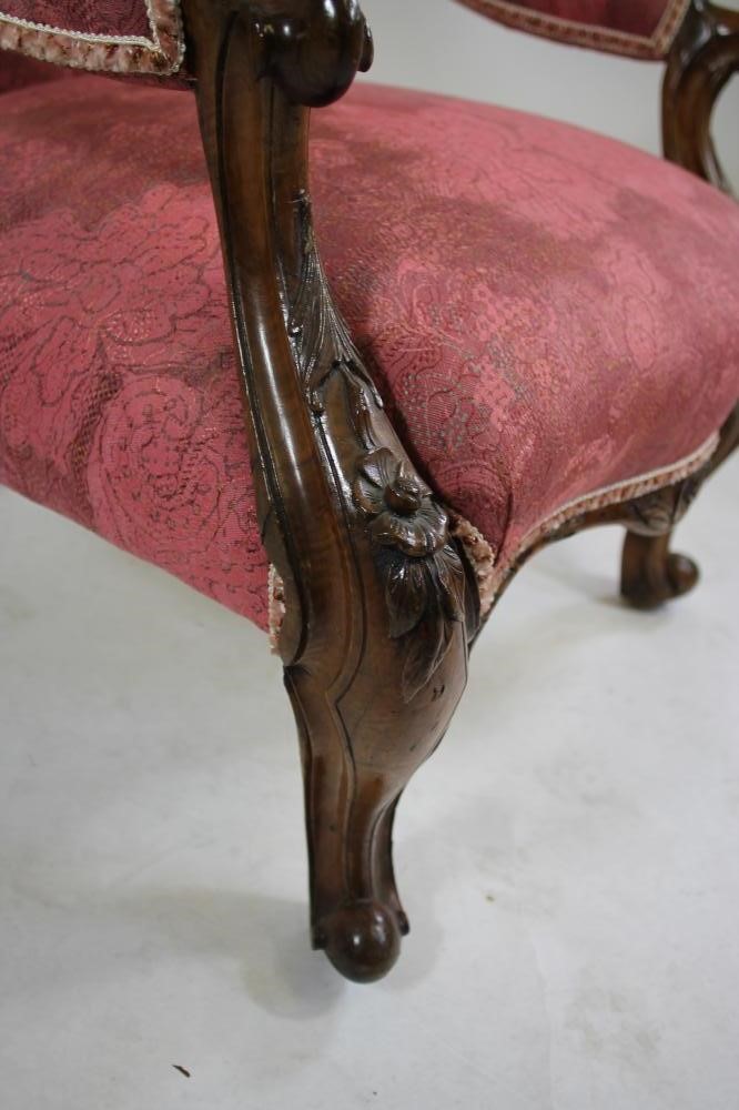 A VICTORIAN WALNUT FRAMED ARM CHAIR of spoonback form button upholstered in raspberry weave Image