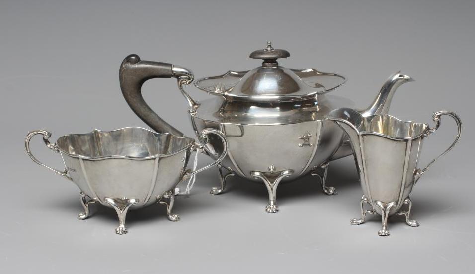 A GEORGE V SILVER ART NOUVEAU THREE PIECE TEA SERVICE by James Deakin & Sons Image