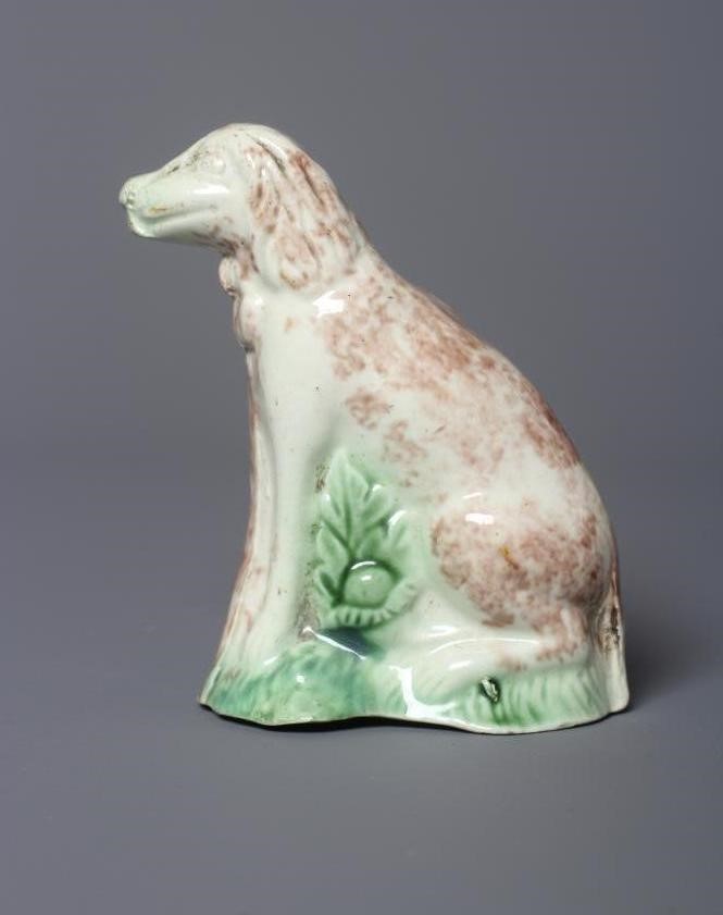 A WHIELDON TYPE CREAMWARE DOG, late 18th century, the seated slip-cast hound with brown sponged Image