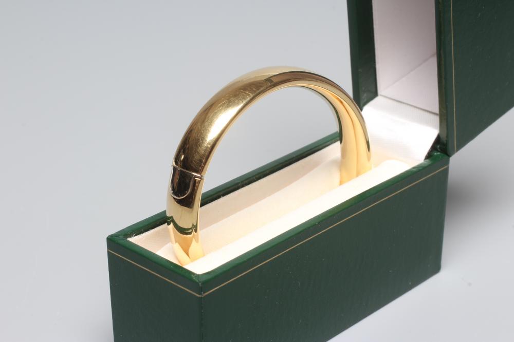 A BANGLE stamped 750, hollow, with exterior push clasp, 23g (Est. plus 24% premium inc. VAT) Image