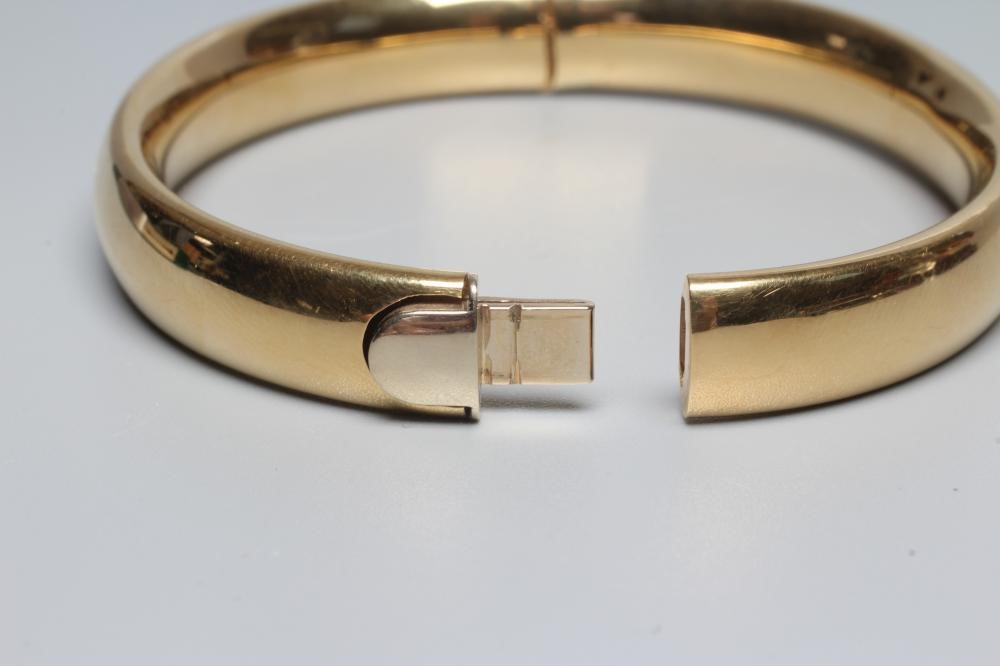 A BANGLE stamped 750, hollow, with exterior push clasp, 23g (Est. plus 24% premium inc. VAT) Image