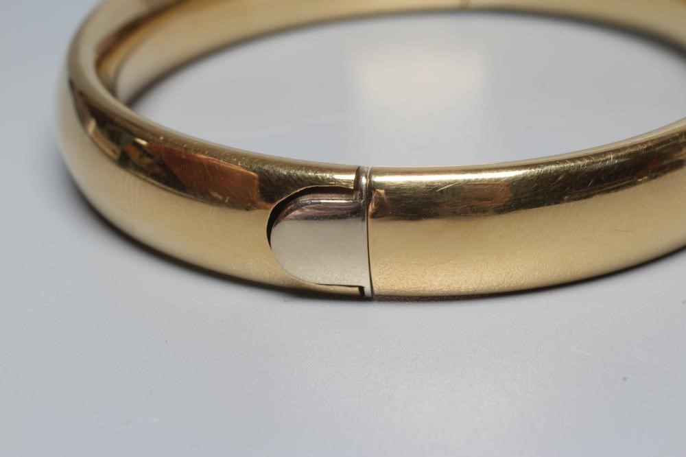 A BANGLE stamped 750, hollow, with exterior push clasp, 23g (Est. plus 24% premium inc. VAT) Image
