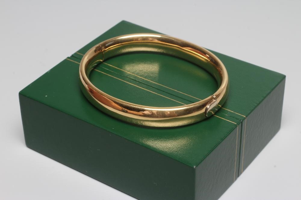 A BANGLE stamped 750, hollow, with exterior push clasp, 23g (Est. plus 24% premium inc. VAT) Image