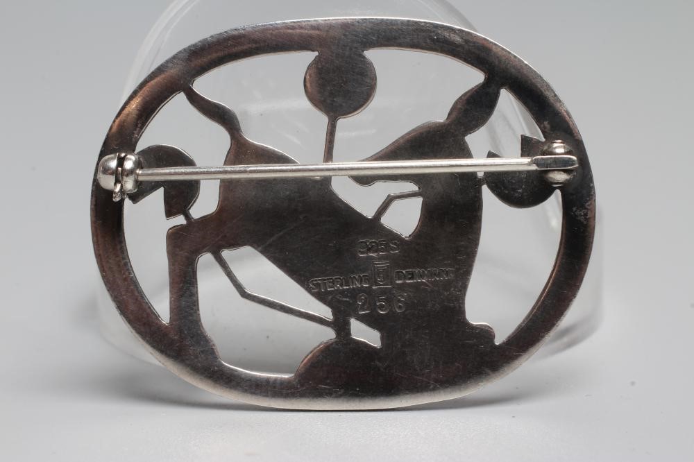 A GEORG JENSEN SILVER OVAL BROOCH designed by Arno Malinowski with a kneeling deer amongst flowers, Image