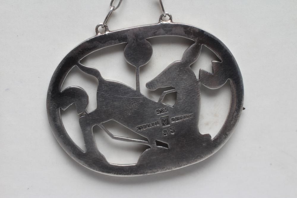 A GEORG JENSEN SILVER OVAL PENDANT designed by Arno Malinowski with a kneeling deer amongst flowers, Image