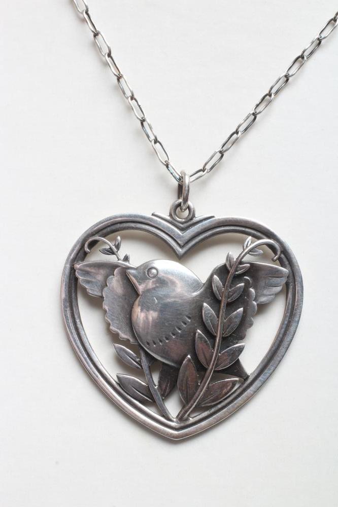 A GEORG JENSEN SILVER DOVE IN HEART PENDANT designed by Arno Malinowski, stamped Sterling 97, on an Image