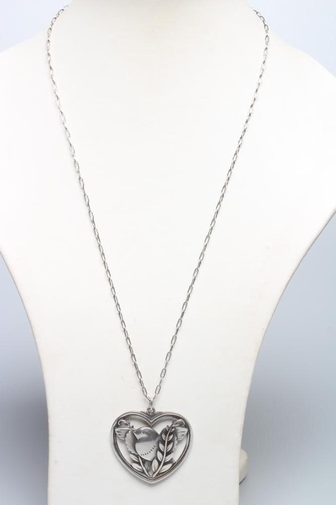 A GEORG JENSEN SILVER DOVE IN HEART PENDANT designed by Arno Malinowski, stamped Sterling 97, on an Image