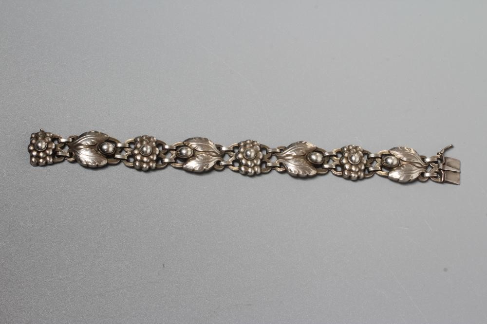 A GEORG JENSEN SILVER BRACELET designed by Georg Jensen with stylised flowerheads and two leaves Image