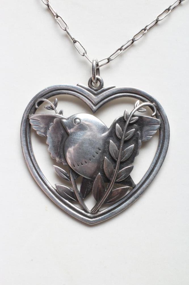 A GEORG JENSEN SILVER DOVE IN HEART PENDANT designed by Arno Malinowski, stamped Sterling 97, on an Image