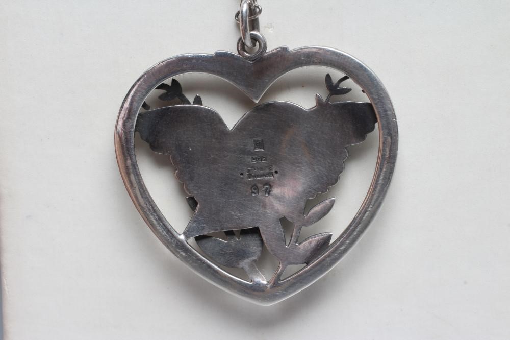A GEORG JENSEN SILVER DOVE IN HEART PENDANT designed by Arno Malinowski, stamped Sterling 97, on an Image