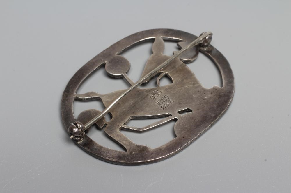 A GEORG JENSEN SILVER OVAL BROOCH designed by Arno Malinowski with a kneeling deer amongst flowers, Image