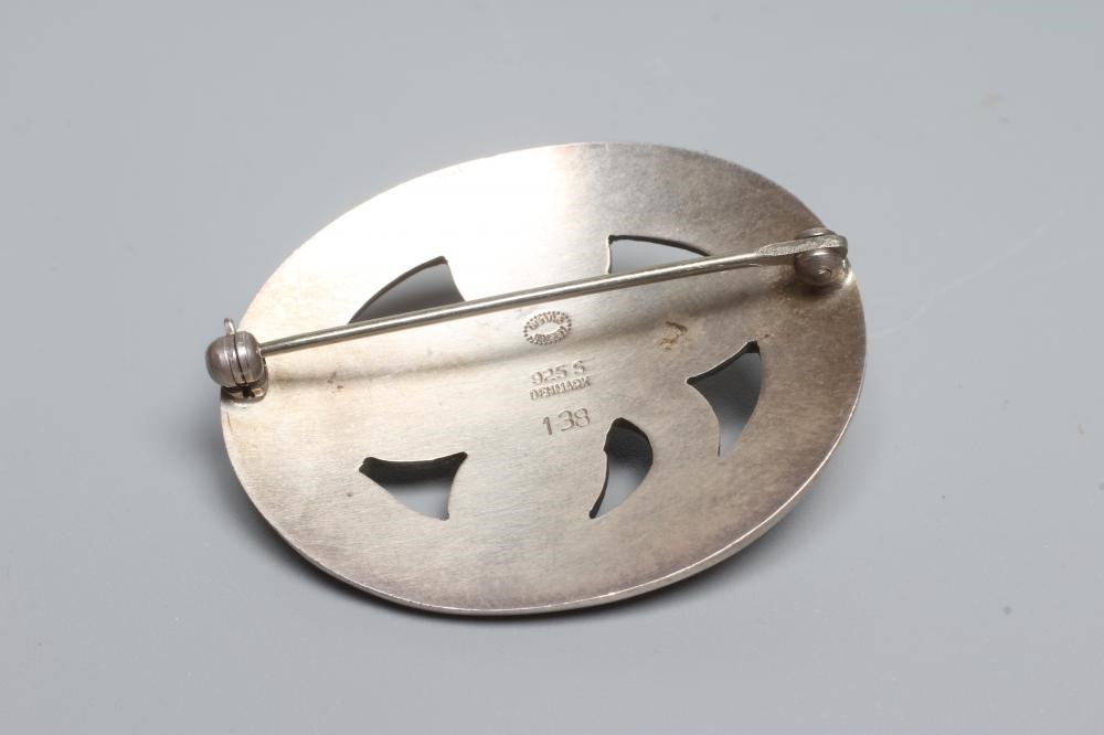A GEORG JENSEN SILVER OVAL BROOCH designed by Georg Jensen as a stylised flowerhead centred by a Image