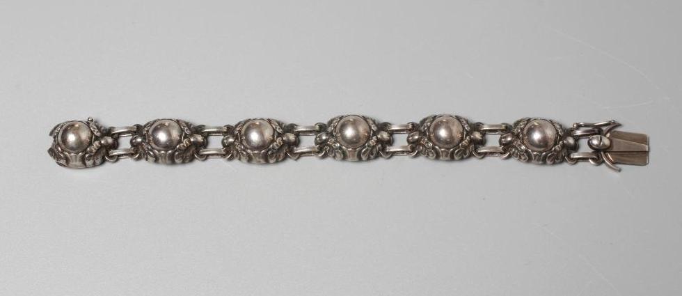 A GEORG JENSEN SILVER BRACELET designed by Georg Jensen as six stylised flowerhead bosses with slide Image