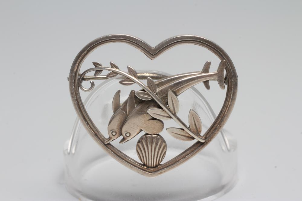 A GEORG JENSEN SILVER HEART BROOCH designed by Arno Malinowski with two dolphins swimming amidst Image