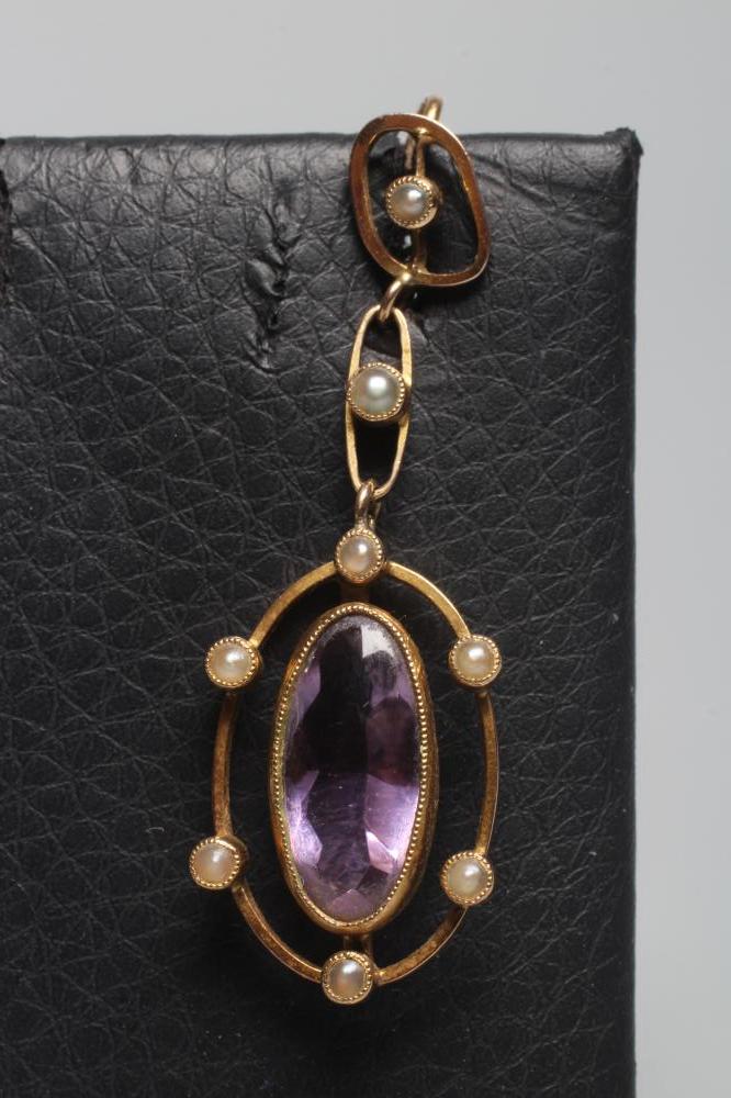 AN EDWARDIAN AMETHYST AND SEED PEARL PENDANT, the oval facet cut amethyst collet set to an open Image