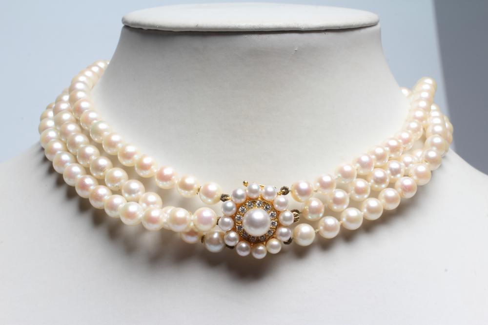 A TRIPLE STRAND CULTURED PEARL NECKLACE, the uniform pearls strung to a diamond and pearl 18ct gold Image