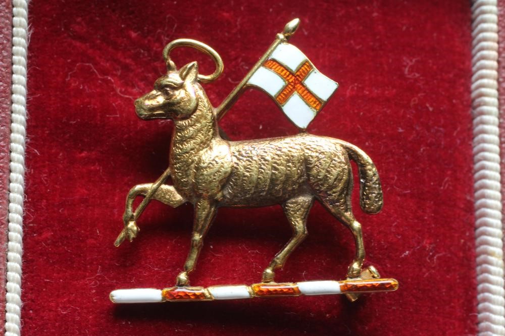 A 14CT GOLD AND ENAMEL QUEEN'S ROYAL REGIMENT BADGE by Garrards Image