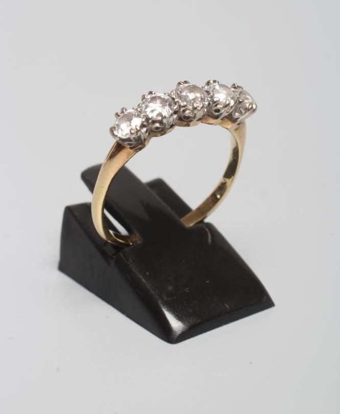 A FIVE STONE DIAMOND RING, the old cut stones each of approximately 0.20cts, claw set to plain Image