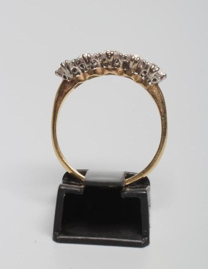 A FIVE STONE DIAMOND RING, the old cut stones each of approximately 0.20cts, claw set to plain Image