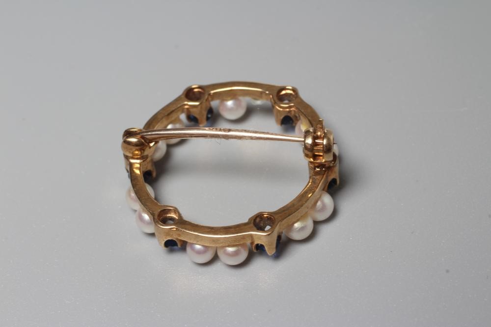 A CULTURED PEARL AND SAPPHIRE WREATH BROOCH peg set with six pairs of small pearls interspersed with Image