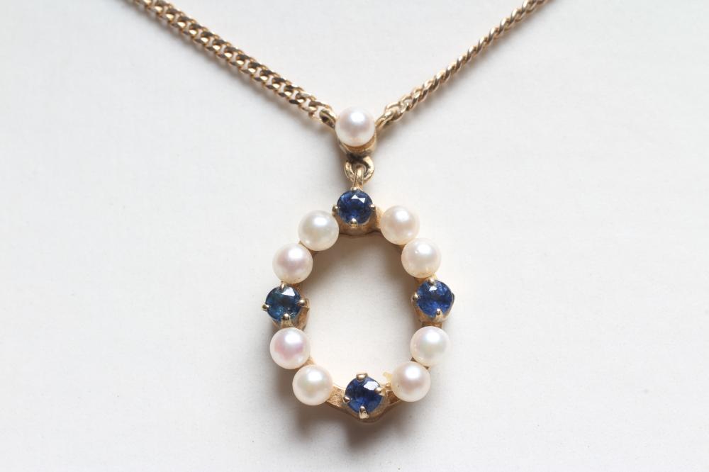 A CULTURED PEARL AND SAPPHIRE OVAL PENDANT peg set with four pairs of small pearls interspersed with Image