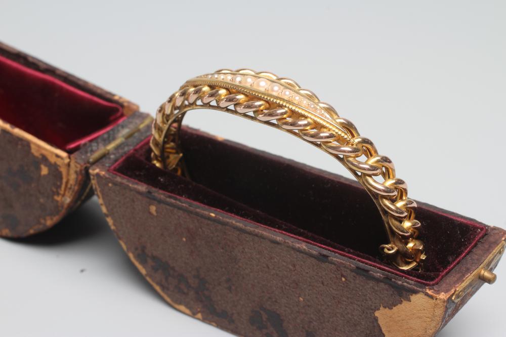 A LATE VICTORIAN ROPE TWIST STIFF HINGED BANGLE, unmarked, the upper section centred by an eliptical Image