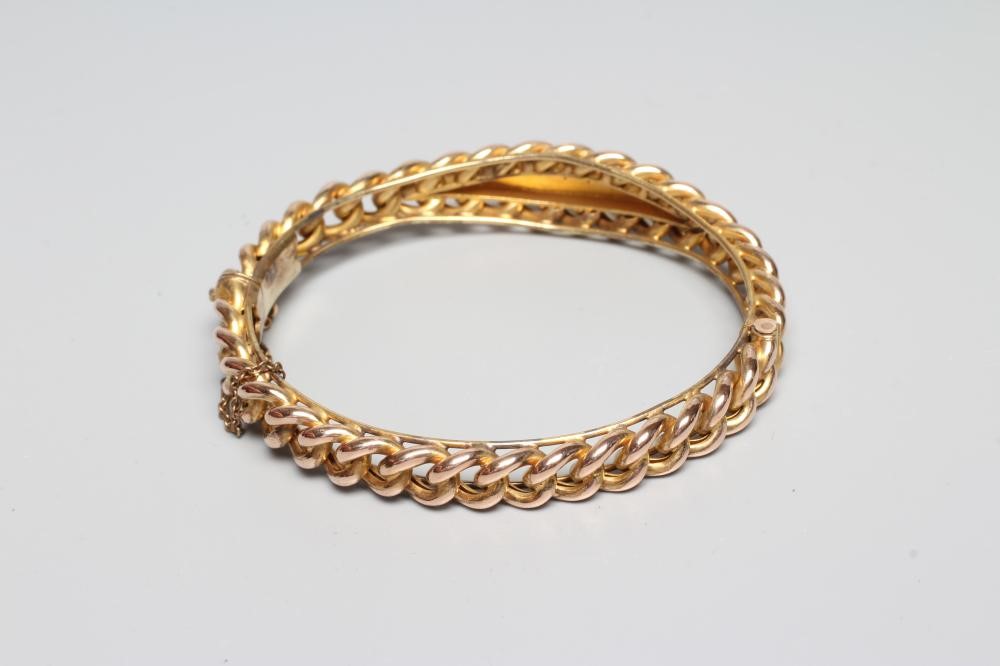 A LATE VICTORIAN ROPE TWIST STIFF HINGED BANGLE, unmarked, the upper section centred by an eliptical Image
