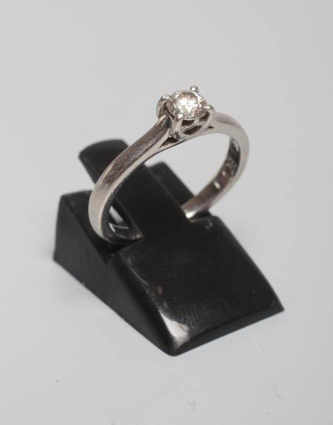 A SOLITAIRE DIAMOND RING, the brilliant cut stone of approximately 0.25cts claw set to a plain Image