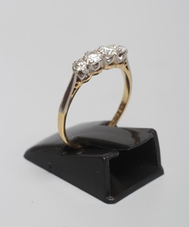 A FOUR STONE DIAMOND RING, the graduating old cut stones totalling approximately 0.50cts claw set to Image