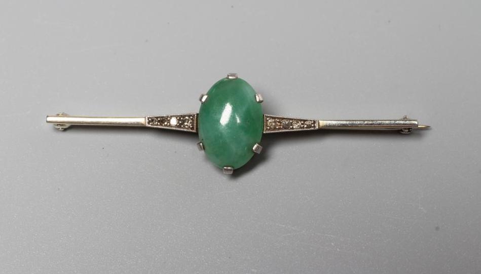 AN ART DECO BAR BROOCH centred by an oval cabochon polished jade panel Image