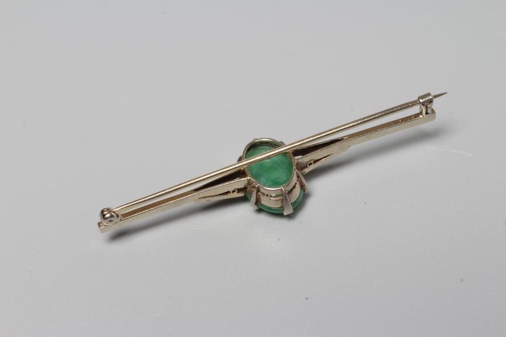 AN ART DECO BAR BROOCH centred by an oval cabochon polished jade panel Image
