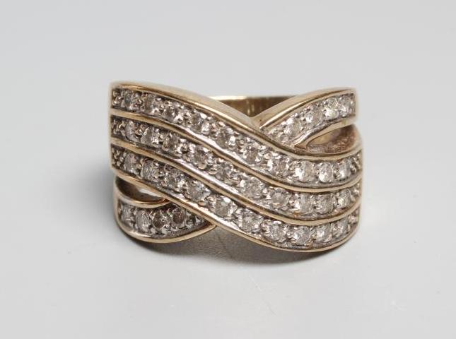 A DIAMOND COCKTAIL RING point set with three diagonal lines of ten small stones with a single Image