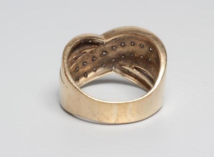 A DIAMOND COCKTAIL RING point set with three diagonal lines of ten small stones with a single Image
